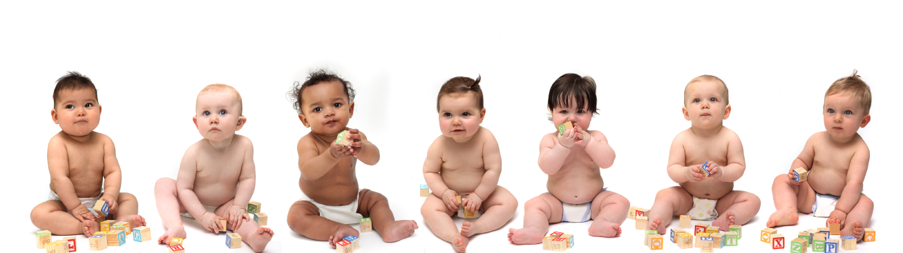 A row of seven happy babies playing with wooden blocks